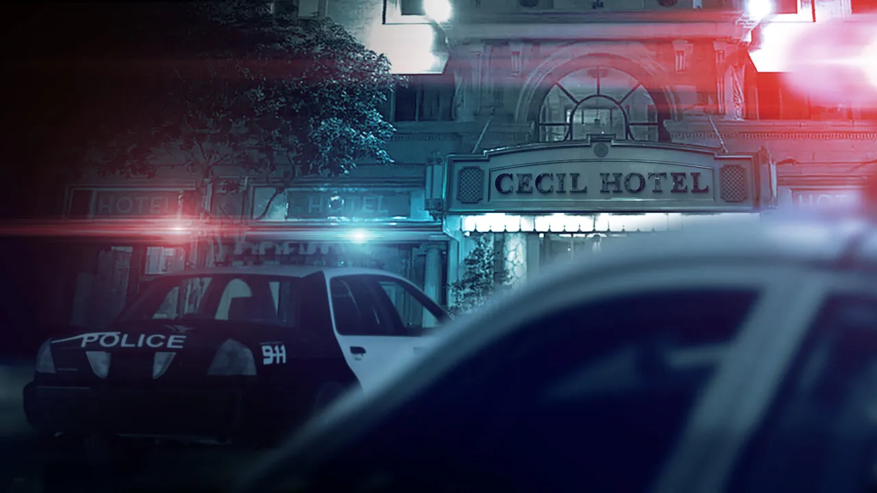 Façade de l'entrée lumineuse du Cecil Hôtel la nuit avec une voiture de police garée au premier plan.